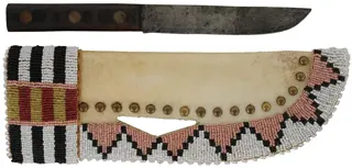 Knife with Beaded Knife Sheath,
6" blade, walnut scales,
11-1/2" long by 3-3/4" wide,
leather and rawhide, brass tacks